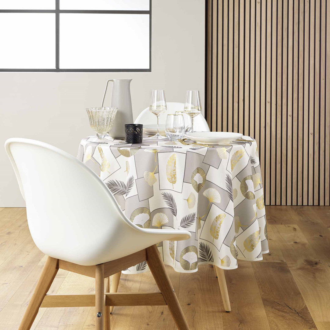 Skapa en elegant dukning med Natane Natural rund duk och dess guldbladsmotiv