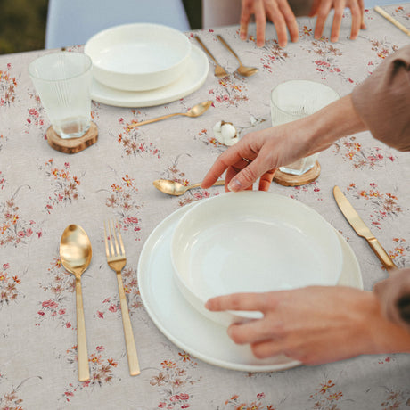 Nordfavn Kassia – Textilvaxduk med blommor på en ljus naturfärgad bakgrund